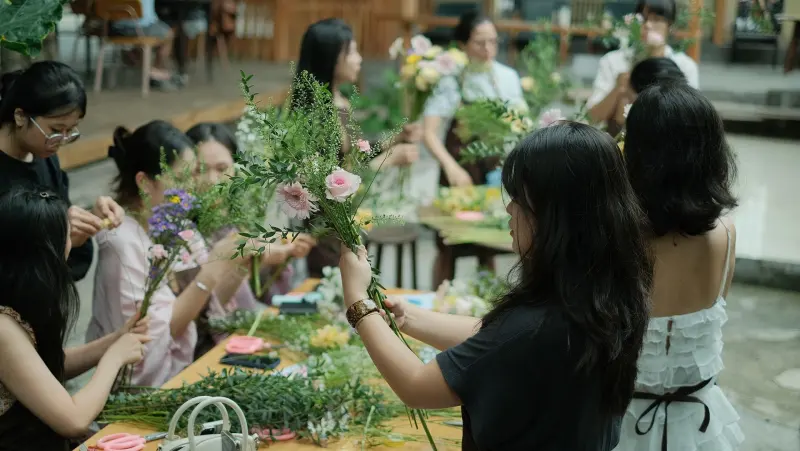 Groupe réuni autour d’une table d’atelier floral